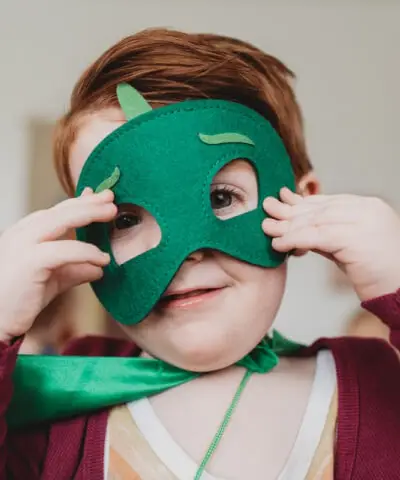 Uśmiechnięte dziecko w zielonej masce na oczy